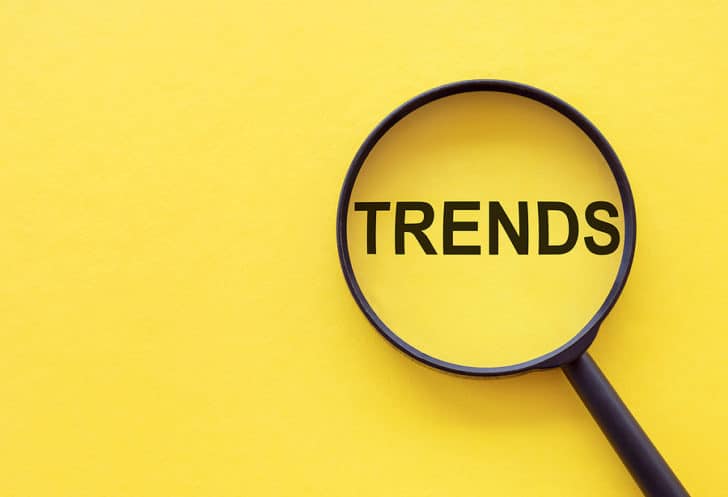 TRENDS text written on magnifier glasses with yellow background