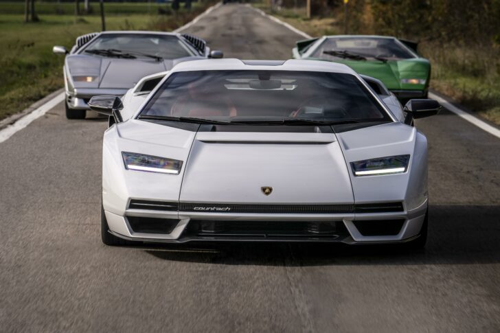 Picture of three Lamborghini cars. A white one is in front with a grey to the back left and green car to the back right.