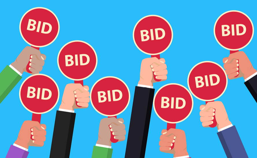 Hands holding bid cards in auction