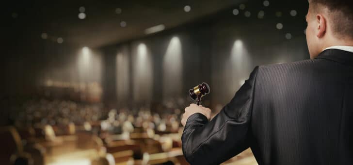 person leading an auction with a gavel in their hand